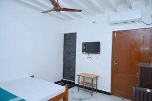 a room with a bed and a ceiling fan at Le Lagrave Inn in Pondicherry