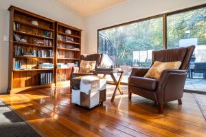 a living room with two chairs and a table and bookshelves at Hidden Lodge Queenstown in Queenstown