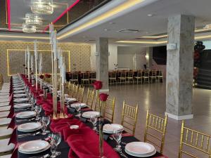 a long row of tables with red napkins and chairs at Hotel Podjadek in Górzno