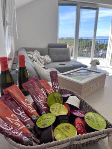 a basket filled with bottles of wine and a couch at Apartman Dani - Sutivan in Sutivan