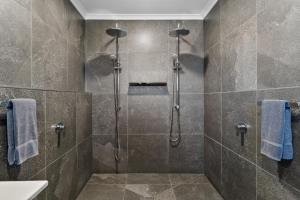 a bathroom with a shower with blue towels at Anchor Wheel Motel in St Helens +75 photos