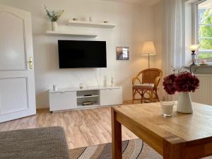 a living room with a flat screen tv on a wall at Haus-Jenina-Ferienwohnung in Cuxhaven