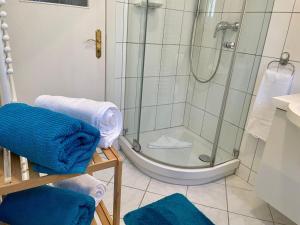 a bathroom with a shower with blue towels in it at Haus-Jenina-Ferienwohnung in Cuxhaven +9 photos