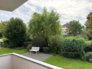 a white bench sitting on a patio in a garden at Haus-Jenina-Ferienwohnung in Cuxhaven