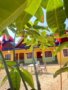 a building with a table and chairs in front of it at KOHRONG khmerhome in Kaôh Rŭng (3)