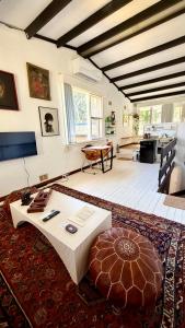 a living room with a coffee table and a rug at MELLOW TREES Lake front studio with sauna in Budgewoi