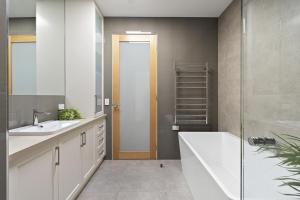 a bathroom with a tub and a sink and a shower at My Place, McCrae in McCrae +20 photos