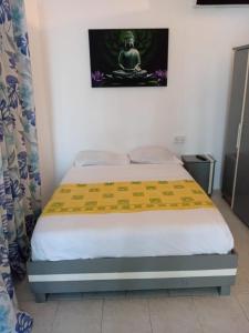 a small bedroom with a bed with a meditationrait at Ven OCEAN VIEW in Grand-Baie