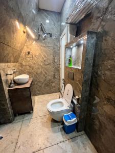 a bathroom with a toilet and a sink at Lawn Side Manor in Jhājra
