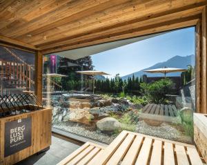 a patio with a large window with a view at Hotel Gassner - 4 Sterne Superior - 1200 qm SPA in Neukirchen am Großvenediger +105 photos