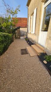 a walkway leading to a door of a house at Studio avec étang in Thaumiers
