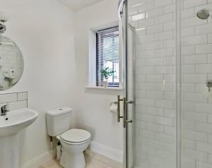 a white bathroom with a toilet and a sink at Riverside Garden B and B in Bishops Village +27 photos