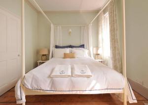 a bedroom with a white bed with two towels on it at The Chocolate-Box * Aldeburgh in Aldeburgh