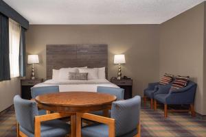 a hotel room with a bed and a table and chairs at Baymont by Wyndham Baldwin in Baldwin