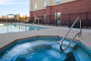 a small swimming pool with metal hand rails next to a building at Hampton Inn Augusta Fort Eisenhower in Augusta