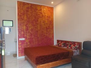 a bedroom with a bed and a red wall at Leaf mountain view holidays rooms in Vagamon