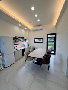 a kitchen and dining room with a table and chairs at 八樂宿 包棟民宿 in Sanxing