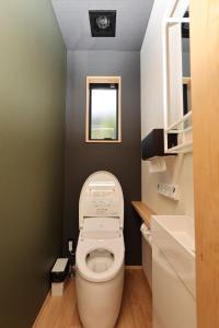 a small bathroom with a toilet and a window at 虎屋旅館 in Kotohira