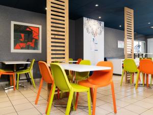 a dining room with tables and colorful chairs at Ibis budget Périgueux in Périgueux