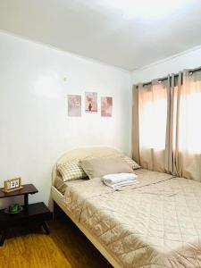 a bedroom with a large bed with a window at Calapan Transient House Xevera in Calapan