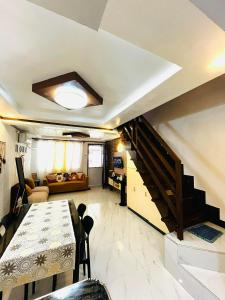 a living room with a table and a staircase at Calapan Transient House Xevera in Calapan +1 photo
