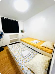a bedroom with two beds and a flat screen tv at Calapan Transient House Xevera in Calapan