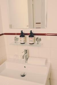 a bathroom sink with two bottles ofodorizers on a mirror at Hôtel Blanca - Orso Hotels in Paris