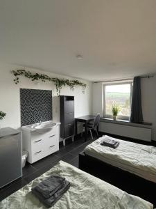 a bedroom with two beds and a sink and a desk at Fuldablick in Melsungen