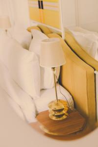 a lamp on a wooden table next to a bed at Hôtel Blanca - Orso Hotels in Paris