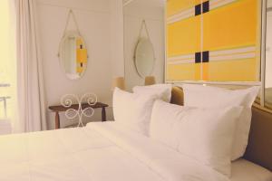 a bedroom with a white bed with white pillows at Hôtel Blanca - Orso Hotels in Paris