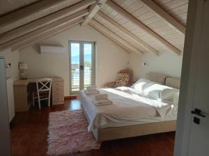 a bedroom with a bed and a desk and a window at ALONI retreat in Proástion