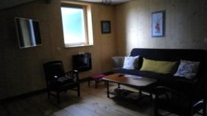 a living room with a couch and a table at Le grenier in Bazas