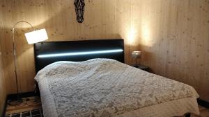 a bedroom with a bed and a lamp in it at Le grenier in Bazas