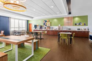 a restaurant with tables and chairs and a counter at Spark by Hilton Shawnee in Shawnee