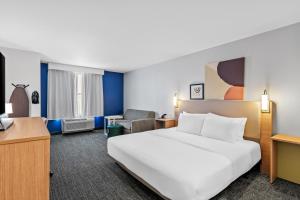 a hotel room with a bed and a desk at Spark by Hilton Shawnee in Shawnee +42 photos