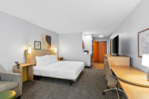 a hotel room with a bed and a desk at Spark by Hilton Shawnee in Shawnee