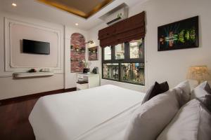 a bedroom with a white bed and a couch at Hanoi TrangTrang Hotel in Hanoi +54 photos