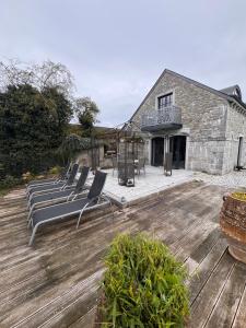 a group of lounge chairs sitting on a wooden deck at Le Durbuy Lodge in Durbuy
