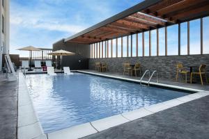 a swimming pool with chairs and tables in a building at Home2 Suites By Hilton Big Spring in Big Spring