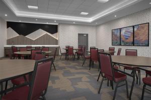 a dining room with tables and red chairs at Home2 Suites By Hilton Big Spring in Big Spring +32 photos