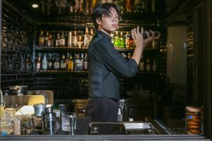 a man standing behind a bar with his hand up at Hanoi TrangTrang Hotel in Hanoi