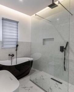 a bathroom with a shower and a tub and a toilet at Paradise View Apartment in Gatunga