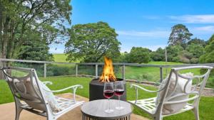 a table with two glasses of wine and a fire pit at Hoddle Lane in Robertson