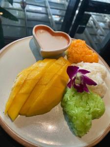 a plate of food with fruit and a sauce at Hostel Cafe13 in Ko Phangan