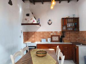 a kitchen with a table and a sink and a stove at Casita Sofia in Caleta de Sebo