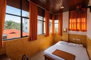 a bedroom with a bed and a large window at Dolphin Residency in Thekkady