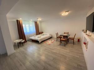 a room with a bed and a table and chairs at Lad Petite Maison in Craiova