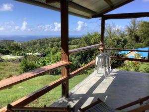 a view from the porch of a house with a chair at Studio Ti Lakaz lao in Petit Brûlé