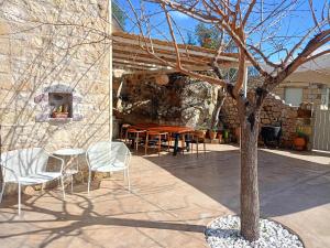 a patio with a table and chairs and a tree at ALONI retreat in Proástion