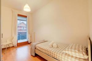 a bedroom with a bed and a window at Magnolia: Laveno Centre 2BR with Terrace - Happy Rentals in Laveno-Mombello